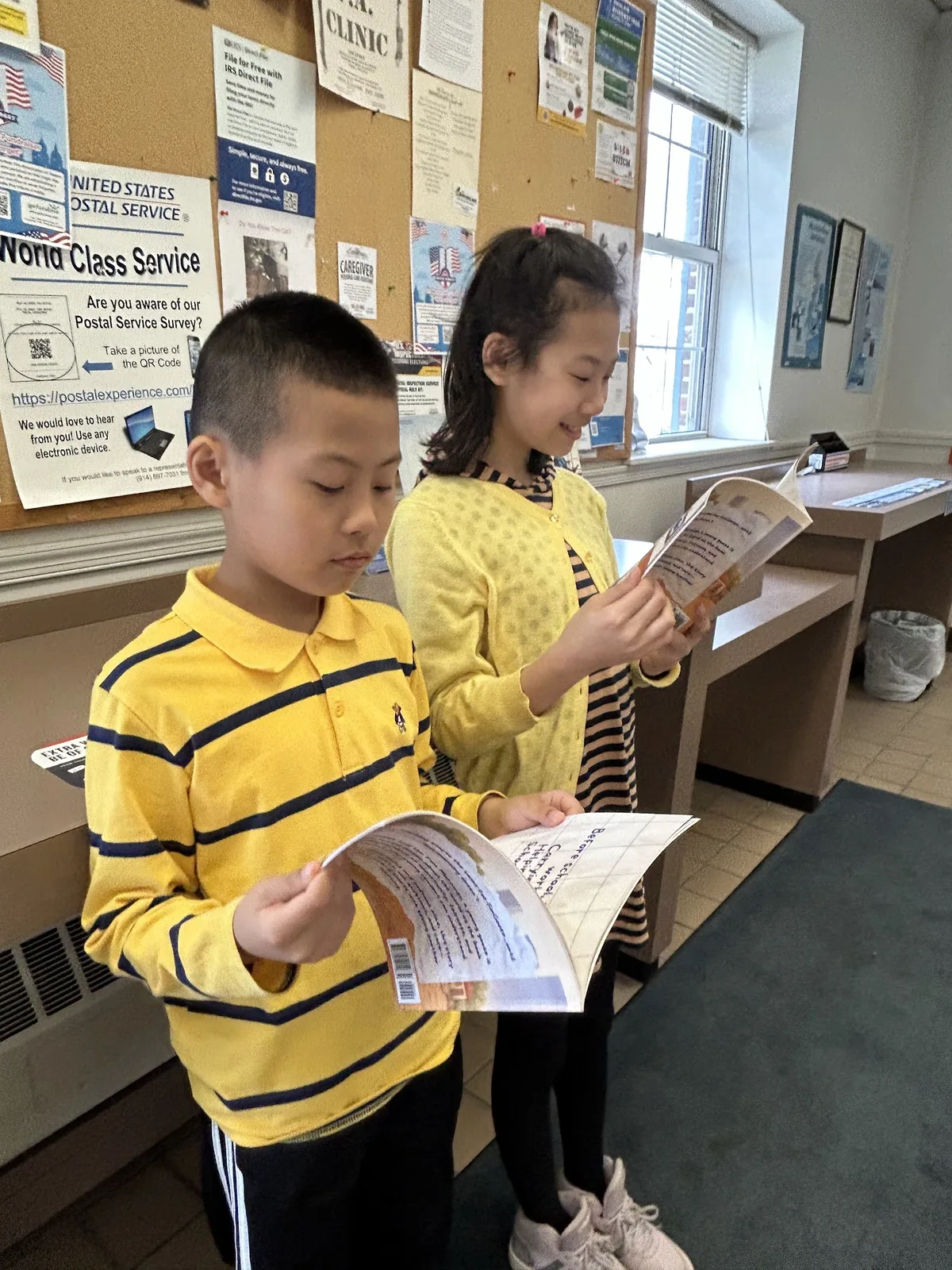 Two students reading FinGoose books
